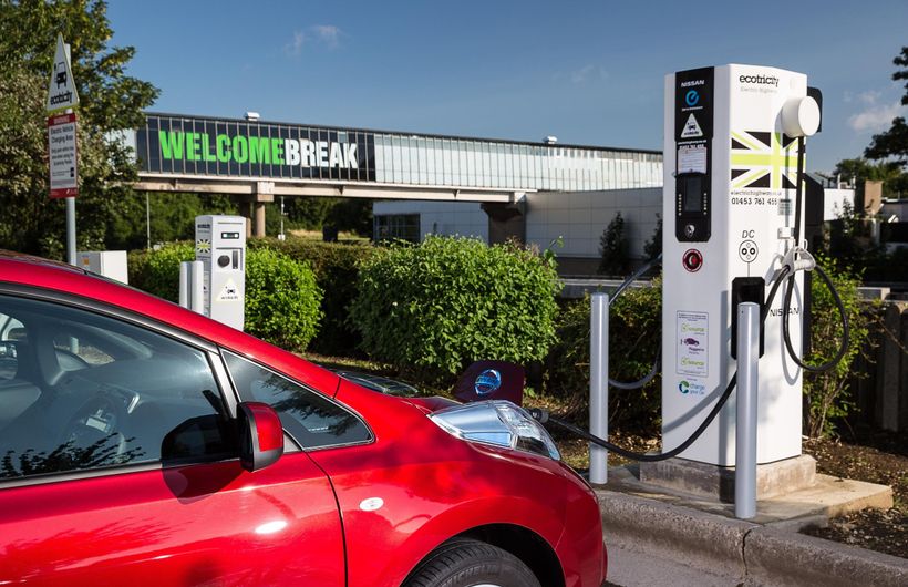 Red Nissan Leaf charging at Ecotricity charge point at Welcome Break motorway services